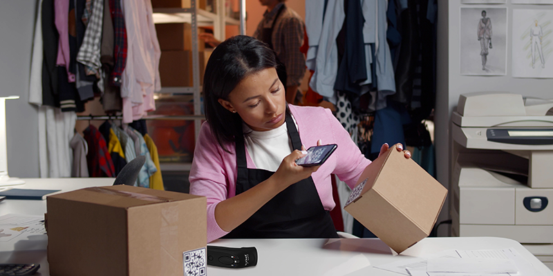 woman scanning box using mobile phone as scanner